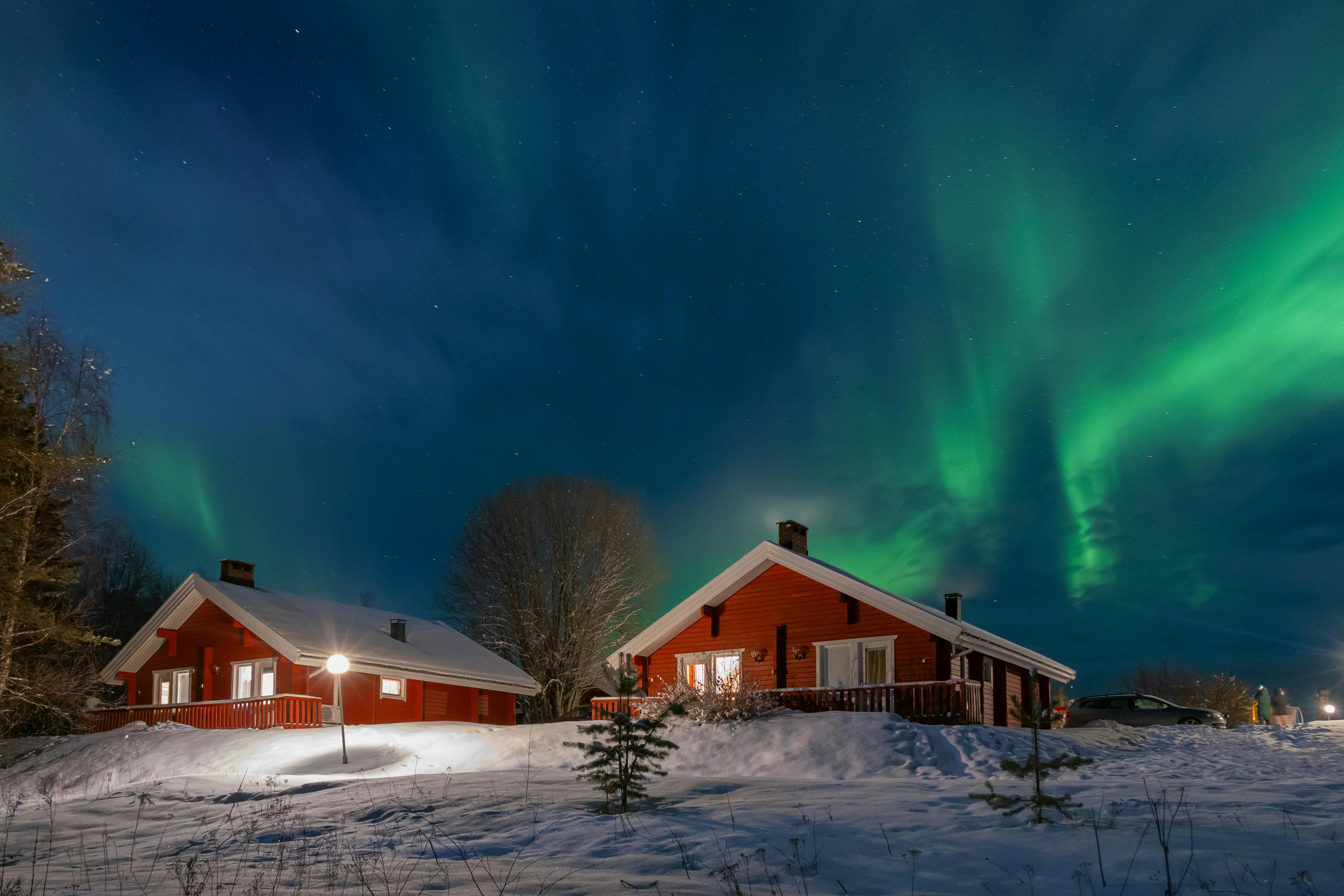 Aurora borealis over a fjord in Finnish Lapland with mountains reflected in calm water
